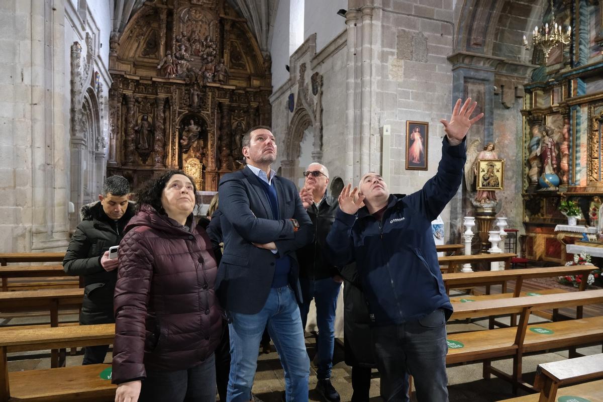 Un momento de la visita a la iglesia de San Pedro de Melide. El conselleiro de Cultura atiende a las explicaciones sobre la restauración que se lleva a cabo en el templo
