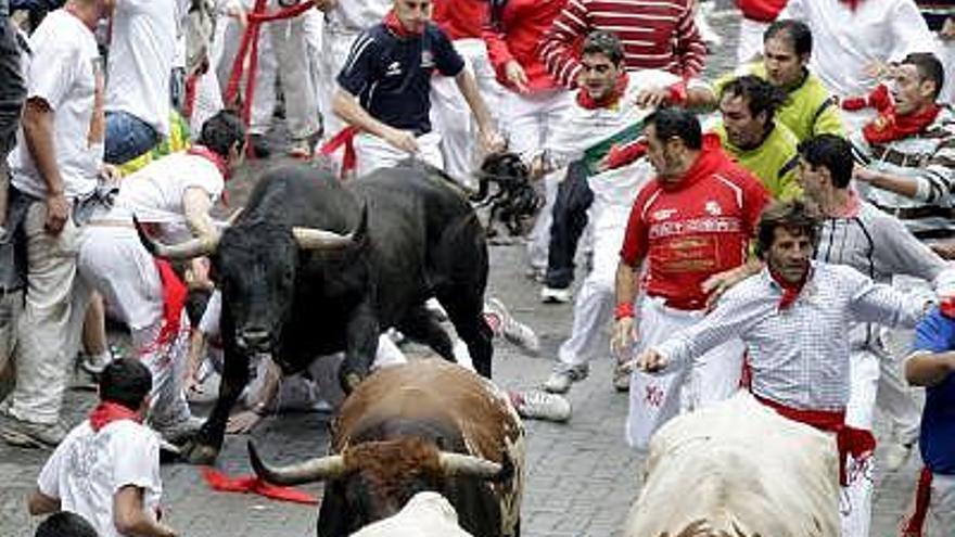 El diestro Juan José Padilla (camisa cuadros dcha) y el Adolfo Suárez Illana (superior derecha) corren junto a otros mozos próximos a los astados de la ganadería sevillana de Eduardo Miura hoy durante el penúltimo encierro de los Sanfermines 2008, que se ha caracterizado por la masificación de corredores por ser domingo, lo que ha complicado la carrera, que a pesar de eso ha sido rápida y sin corneados.