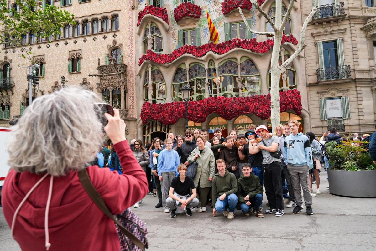 Turistas se toman fotos frente a Casa Batló, vestida de rosas por Sant Jordi