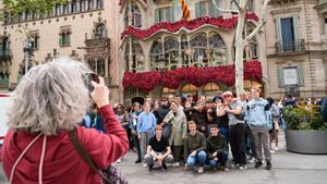 Turistas se toman fotos frente a Casa Batló, vestida de rosas por Sant Jordi