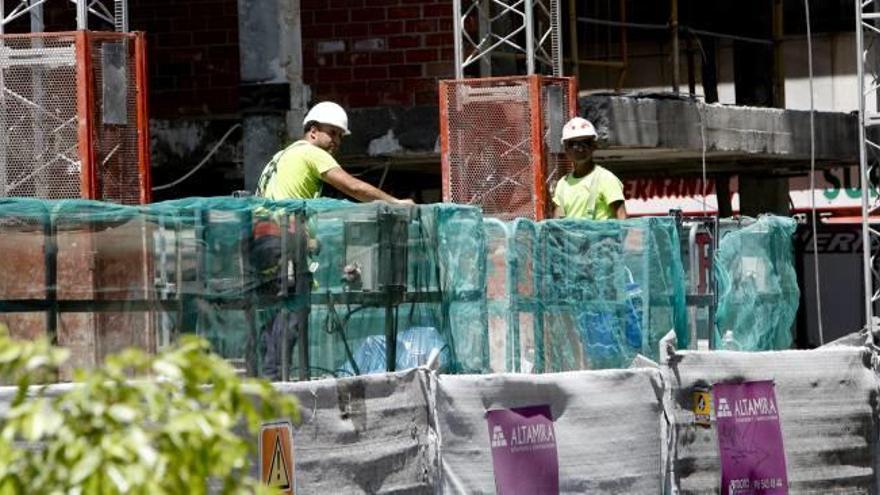 Dos operarios trabajan en la rehabilitación de un edificio en Alicante en una imagen de archivo.