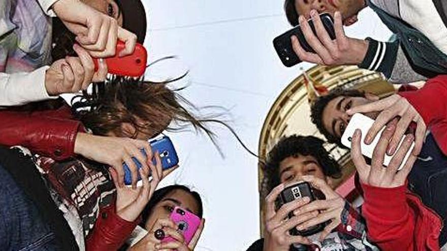 Un grupo de adolescentes posa con sus teléfonos móviles.