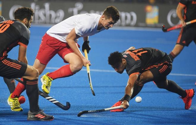 Brenden Bissett (C) lucha por el balón con Glenn Schuurman (R) durante el partido de cruce de hockey sobre césped entre Canadá y Netherland en la Copa Mundial de Hockey 2018 en Bhubaneswar.