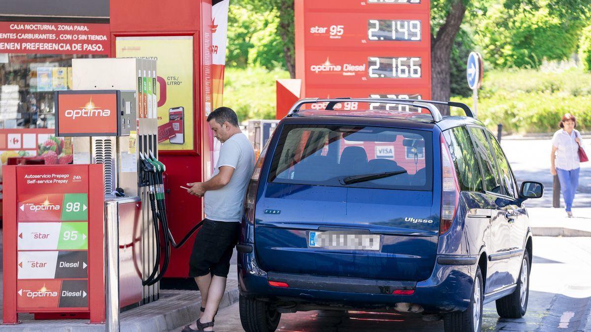 Un hombre echa gasolina en una estación de servicio.