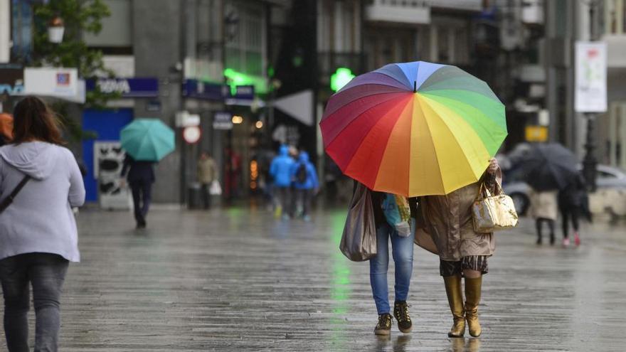 Varias personas con paraguas en el centro de A Coruña.