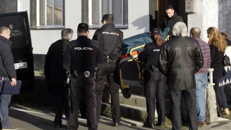 Los servicios funerarios sacan el cadáver de la mujer.