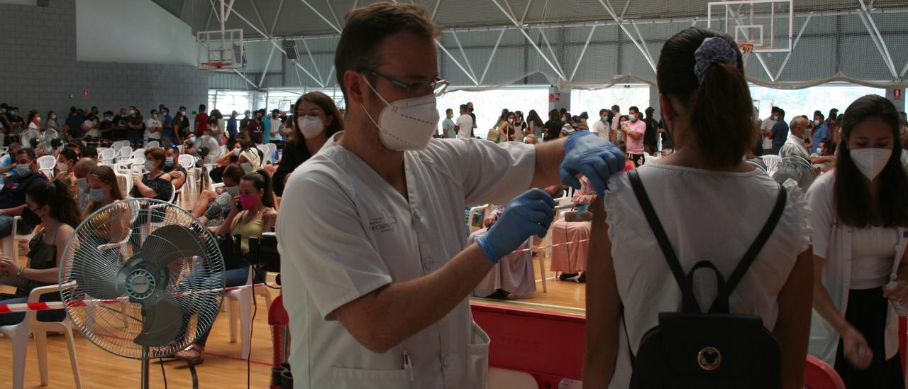 Un sanitario realizando la prueba del PCR a una paciente.