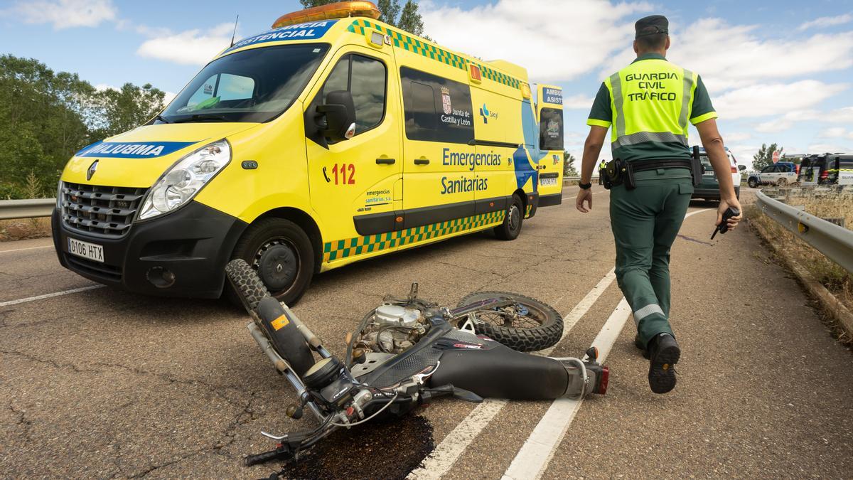 Un miembro de la Guardia Civil junto a la motocicleta que conducía el herido.
