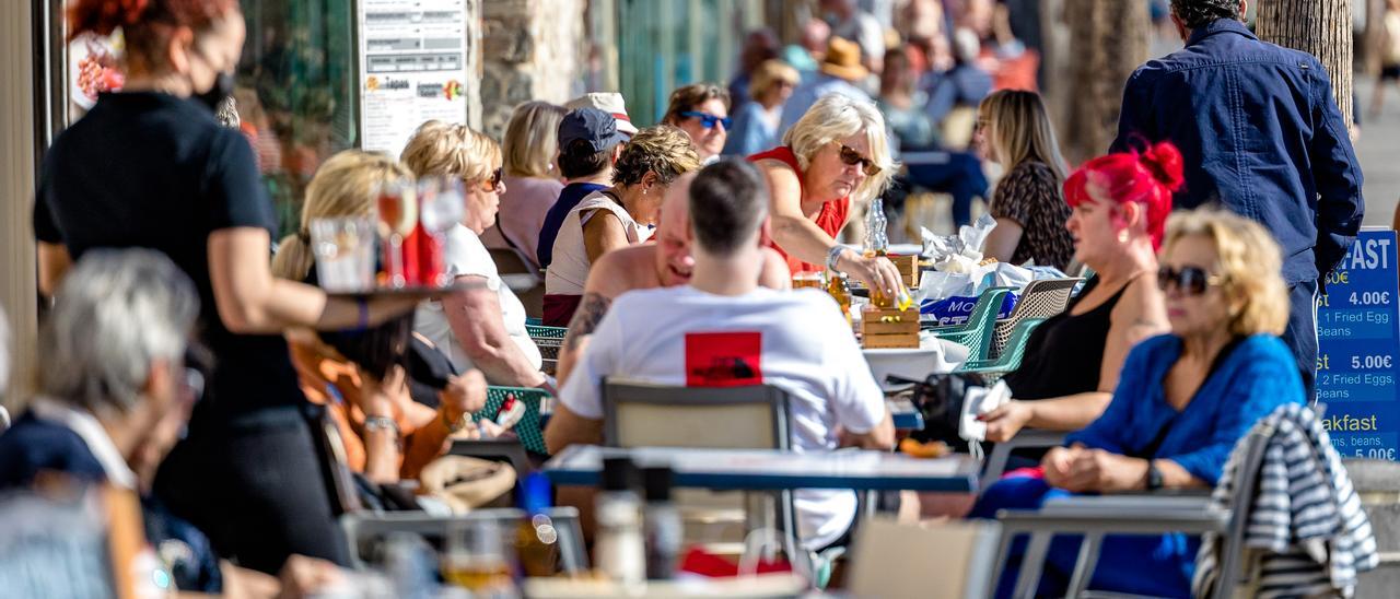 Un camarera atiende la terraza de un restaurante en Benidorm