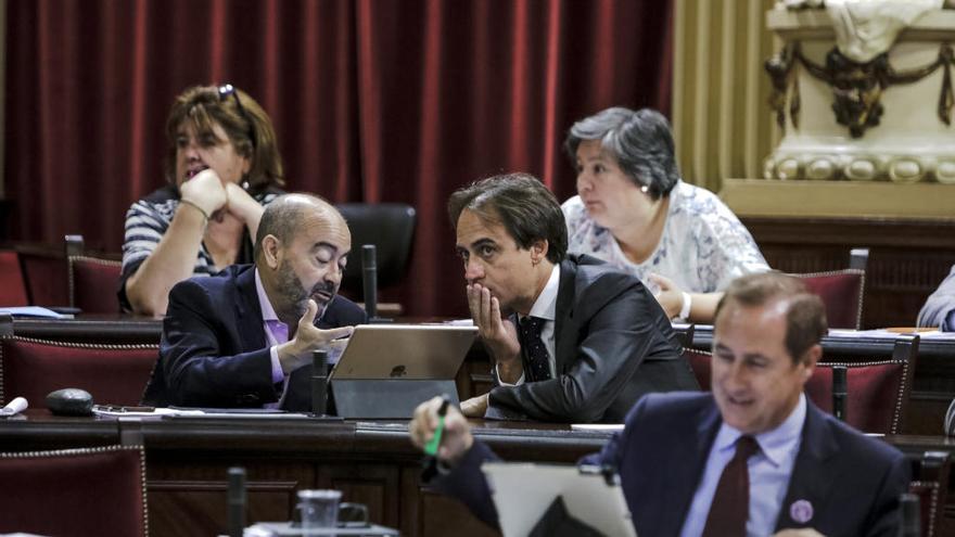 El diputado del PP, Álvaro Gijón (derecha), charlando ayer en su escaño en el Parlament con su compañero de partido Toni Gómez.