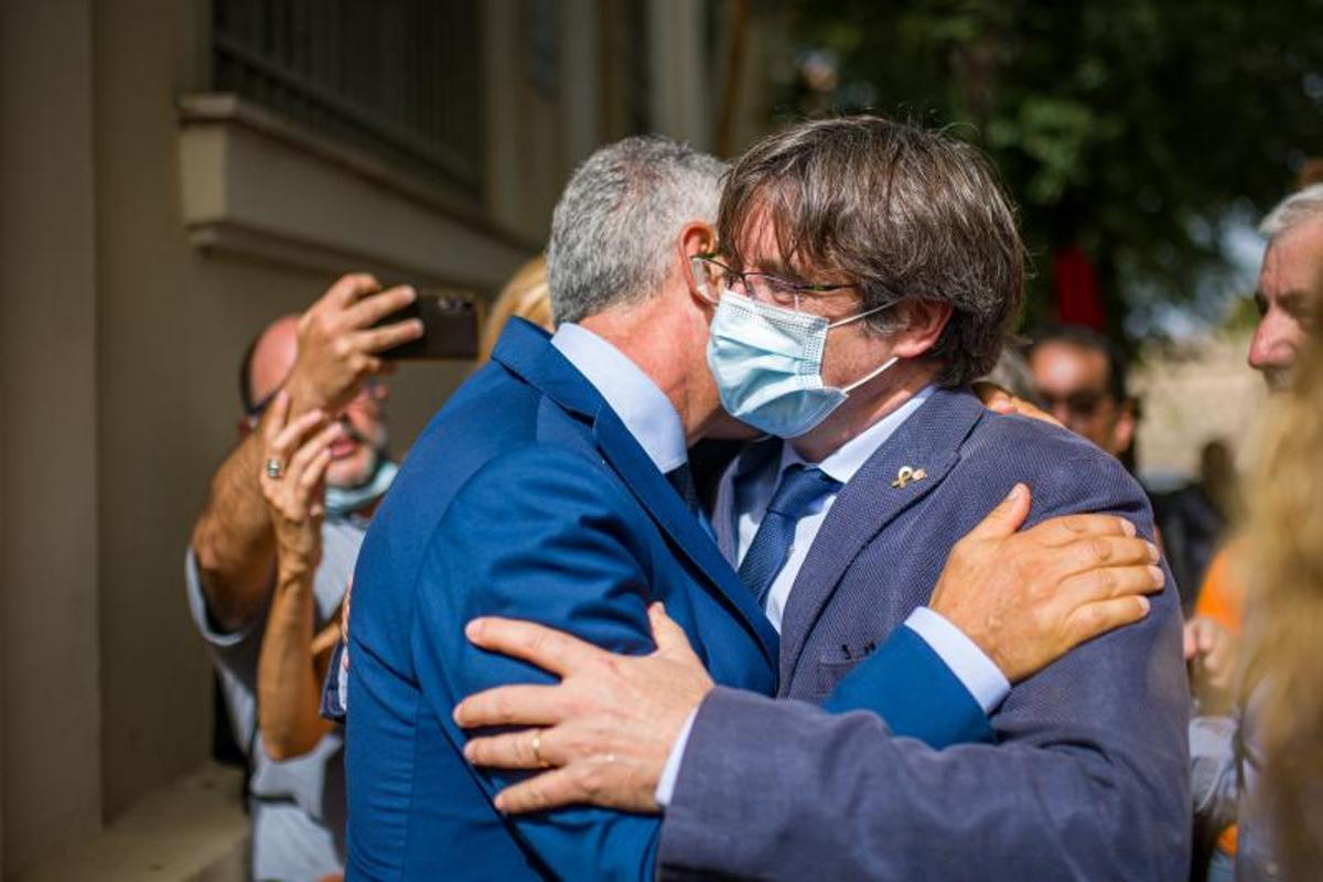 El alcalde de L'Alguer, Mario Conoci, y el 'expresident' de la Generalitat Carles Puigdemont, se saludan en el festival Adifolk, en la localidad italiana, este 25 de septiembre de 2021.