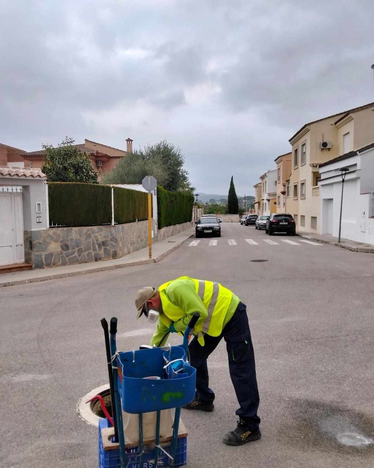 Un operario aplica el tratamiento contra las plagas en la red de alcantarillado de l'Olleria.