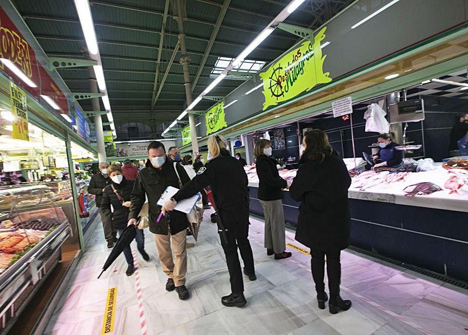 Una empleada de seguridad, de espaldas, pidiendo distancia a los clientes del Fontán.