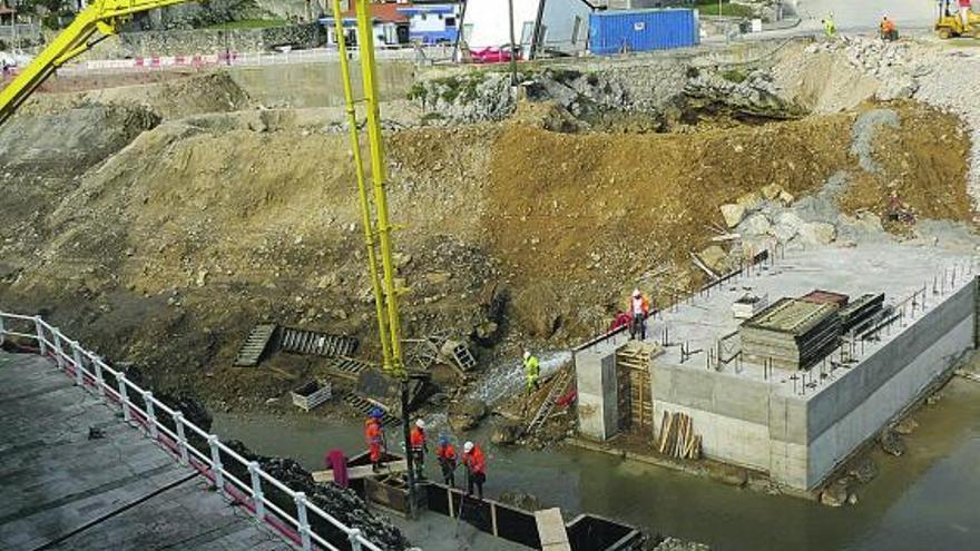 Operarios trabajando, ayer, en la futura compuerta de entrada a la dársena llanisca.