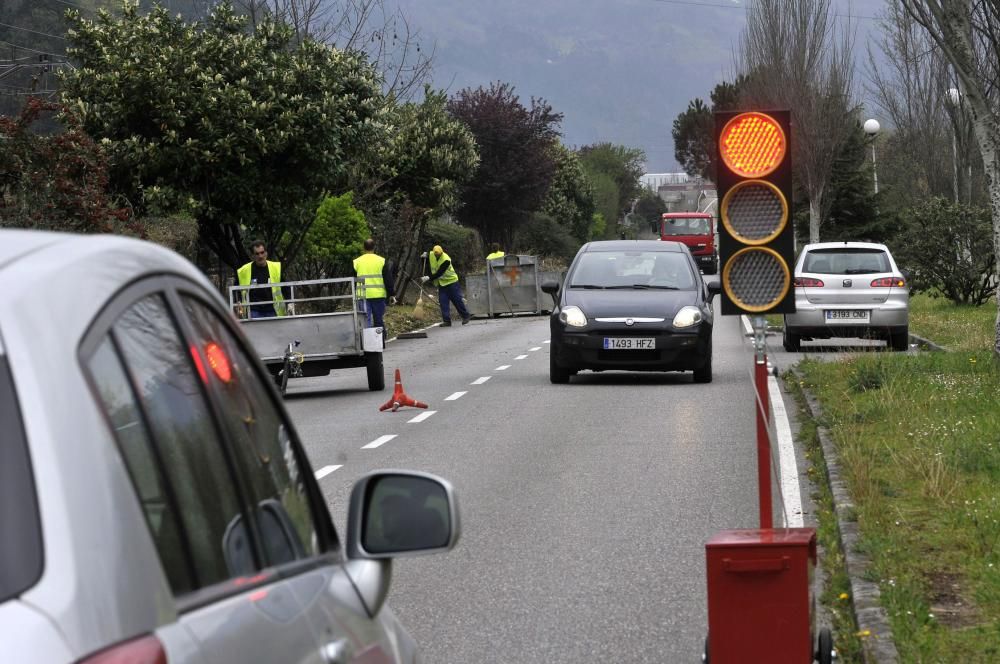 Trabajadores municipales en labores de desbroce en el paseo fluvial de Mieres con paso alternativo de vehículos