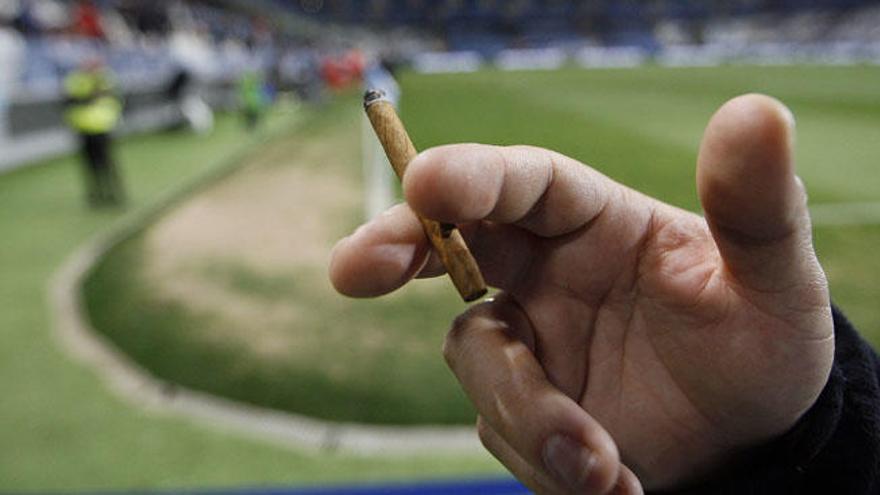 Un aficionado se enciende un cigarro durante un partido disputado en La Rosaleda.