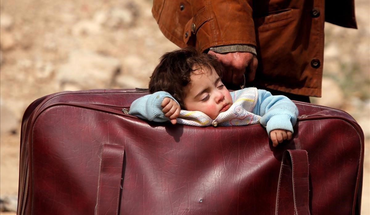 Niño durmiendo en una maleta en el pueblo de Beit Sawa, Siria, el 15 de marzo.