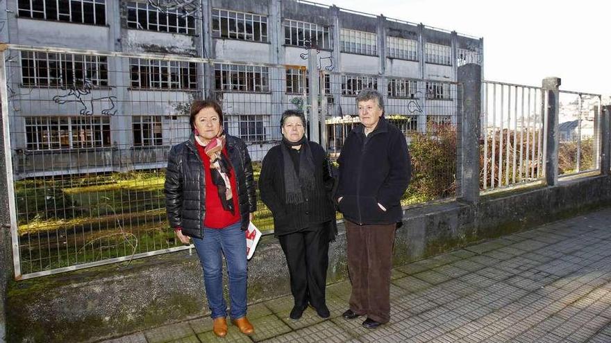 Las extrabajadoras Manuela, Esther y Nieves, ante la fábrica abandonada de GEA en Cabral. // J. Lores