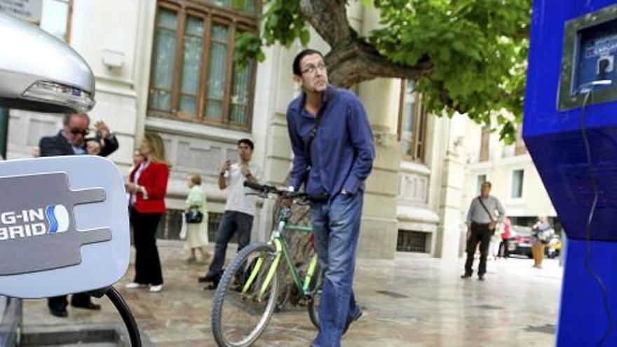 Un hombre observa la primera cabina telefónica de la Comunidad Valenciana, situada en la plaza del Ayuntamiento