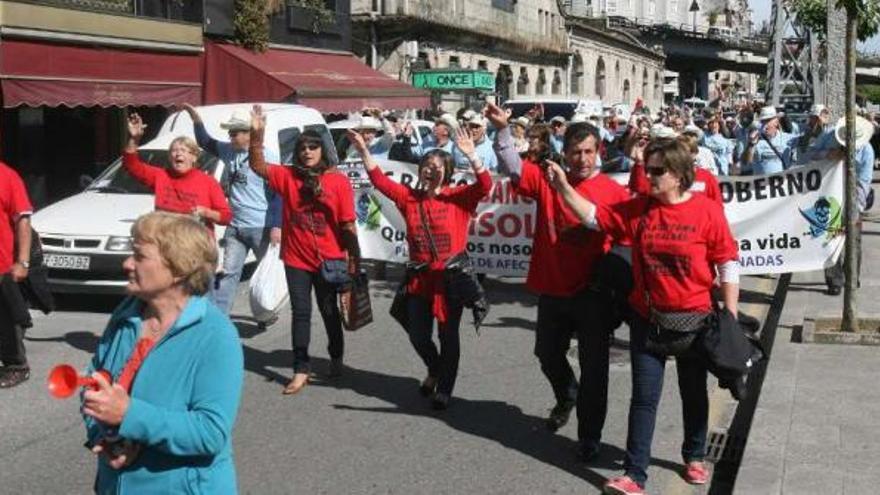 Los afectados por las preferentes, ayer, durante la protesta por el centro de Redondela.  // Jesús de Arcos