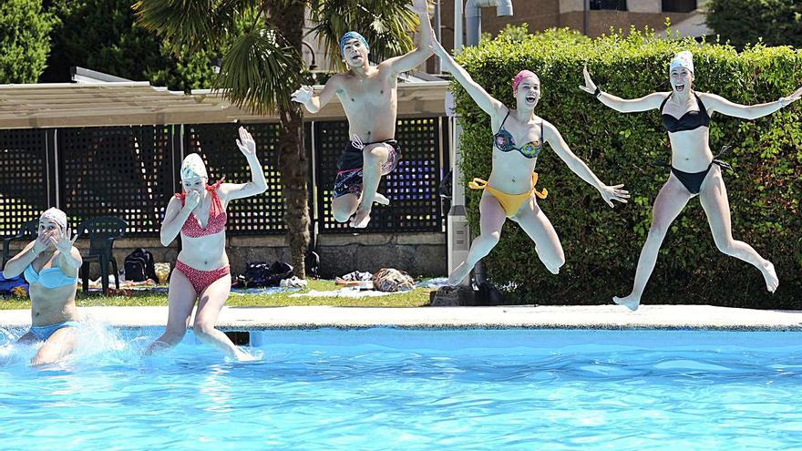 Jóvenes lanzándose a la piscina en Rodeiro, ayer.