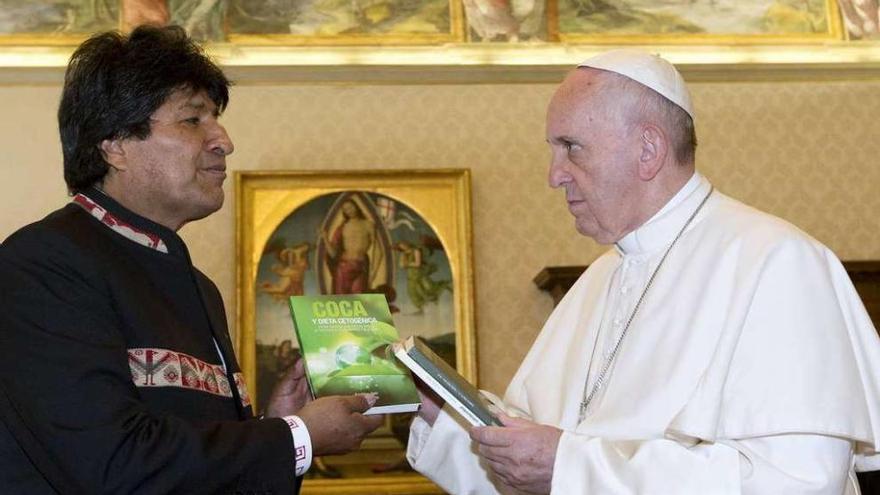 El presidente de Bolivia entrega a Francisco tres libros sobre la coca.