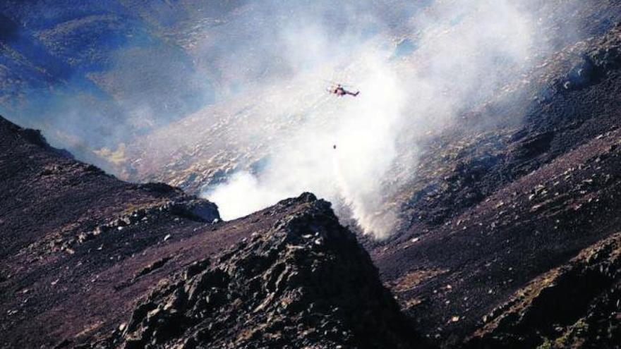 Un helicóptero lanza agua ayer sobre un incendio declarado en Vilariño de Conso. / brais lorenzo