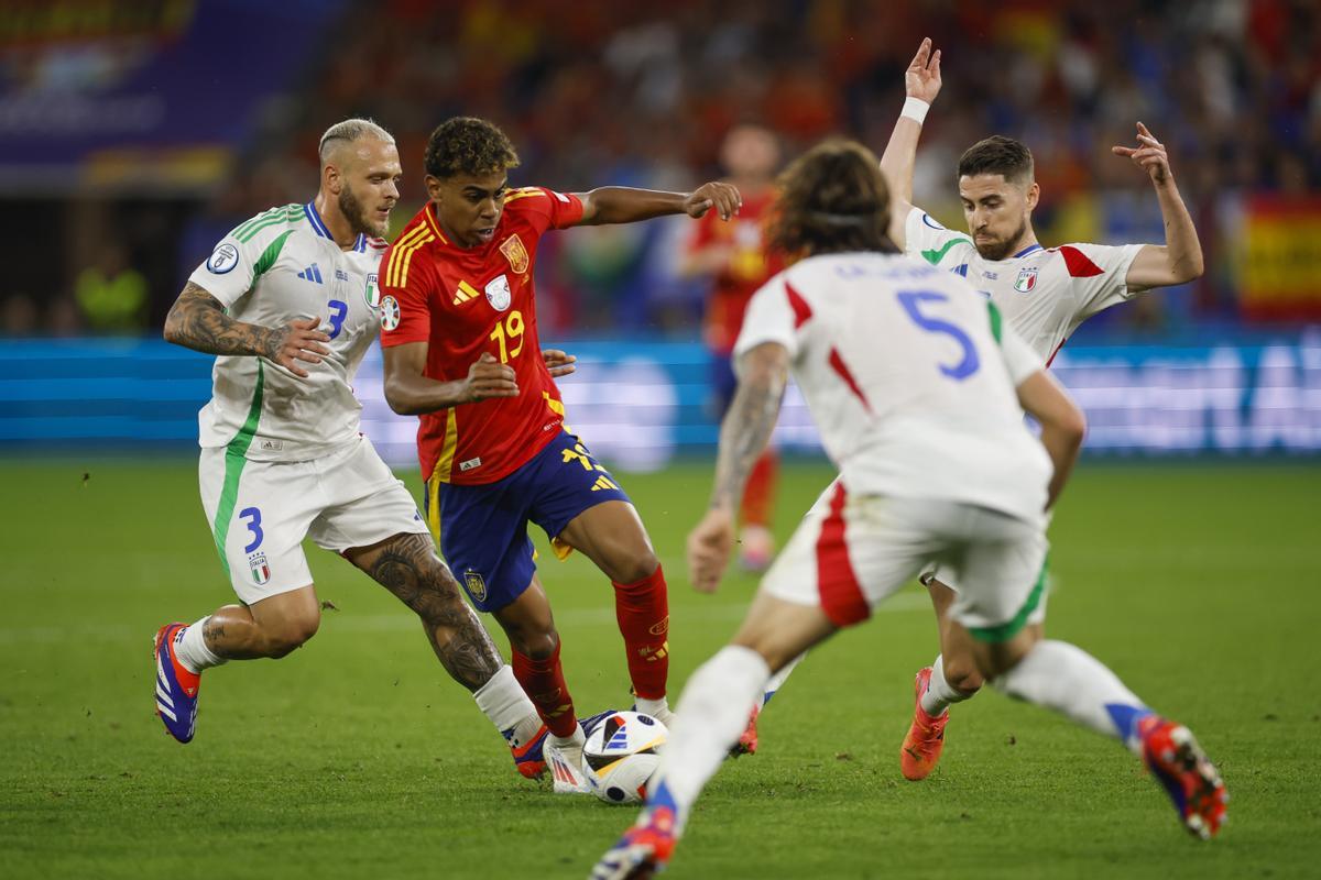 El delantero de la selección española, Lamine Yamal, intenta llevarse el balón ante los defensores de la selección italiana en la Eurocopa 2024