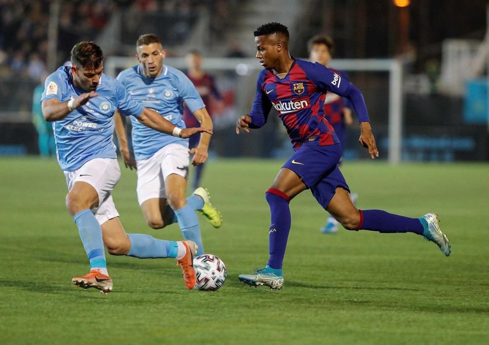 El delantero hispano-guineano del FC Barcelona Ansu Fati (d) disputa un balón con Kike López, defensa español del UD Ibiza, el centrocampista Josep Caballé (d)