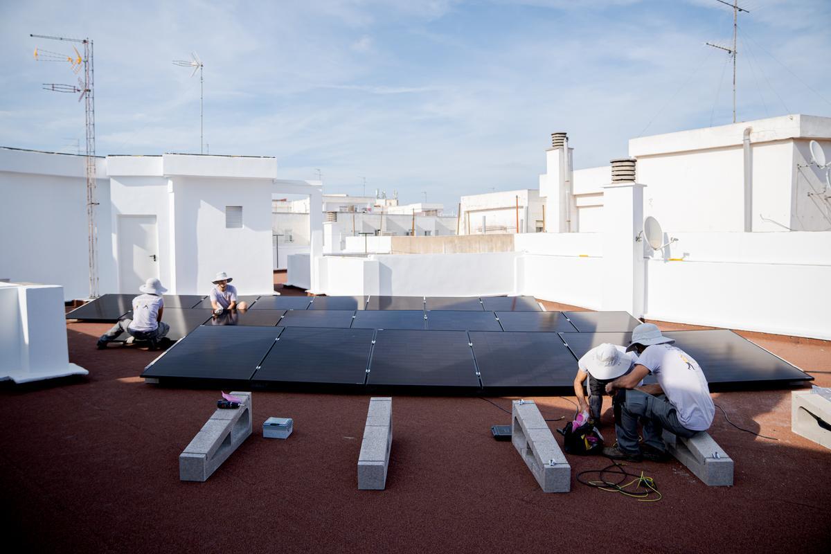 Trabajos de instalación de placas solares por parte de una cooperativa.