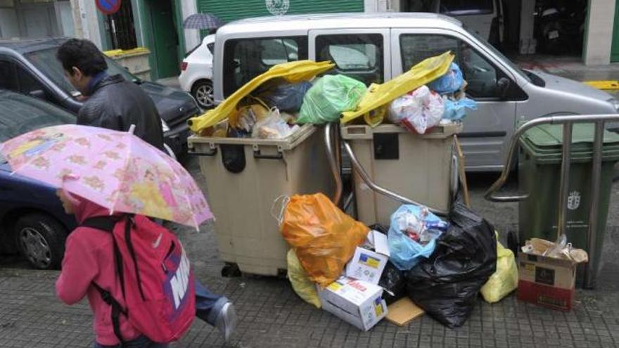 Contenedores llenos de basura en una calle de la ciudad. / víctor echave