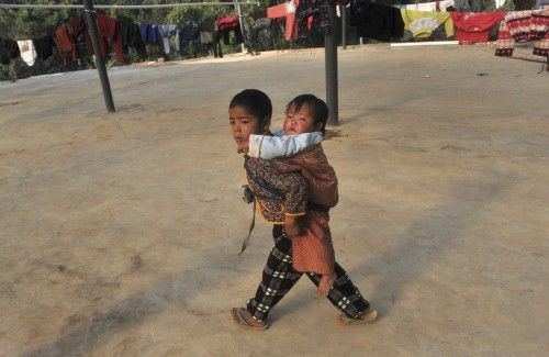 Un niño de Kokang lleva a su hermana en un campo de refugiados