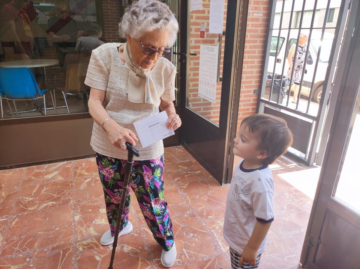 Un abuela muestra a su nieto un sobre con el voto al Congreso en Quiruelas de Vidriales.