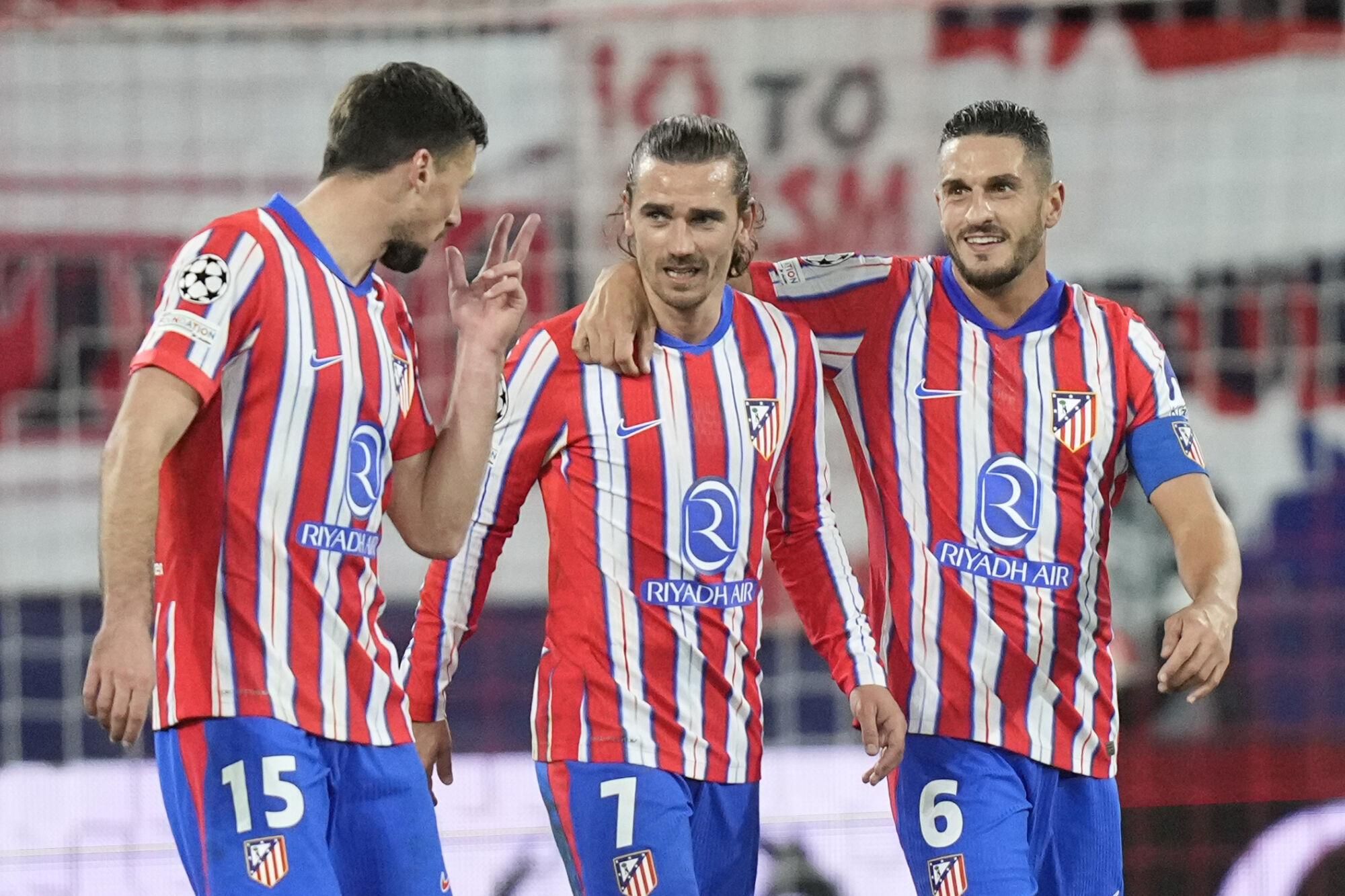 Atletico Madrid's Antoine Griezmann, center, celebrates after scoring his side's 3rd goal with his teammates Clement Lenglet, left, and Koke during the Champions League opening phase soccer match between FC Salzburg and Atletico Madrid at the Salzburg Arena in Salzburg, Austria, Wednesday, Jan. 29, 2025. (AP Photo/Matthias Schrader)