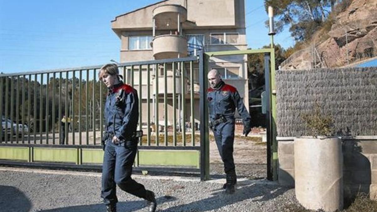 Dos mossos salen de la casa de L'Ametlla de Merola, en Puig-reig. escenario de un asesinato machista.