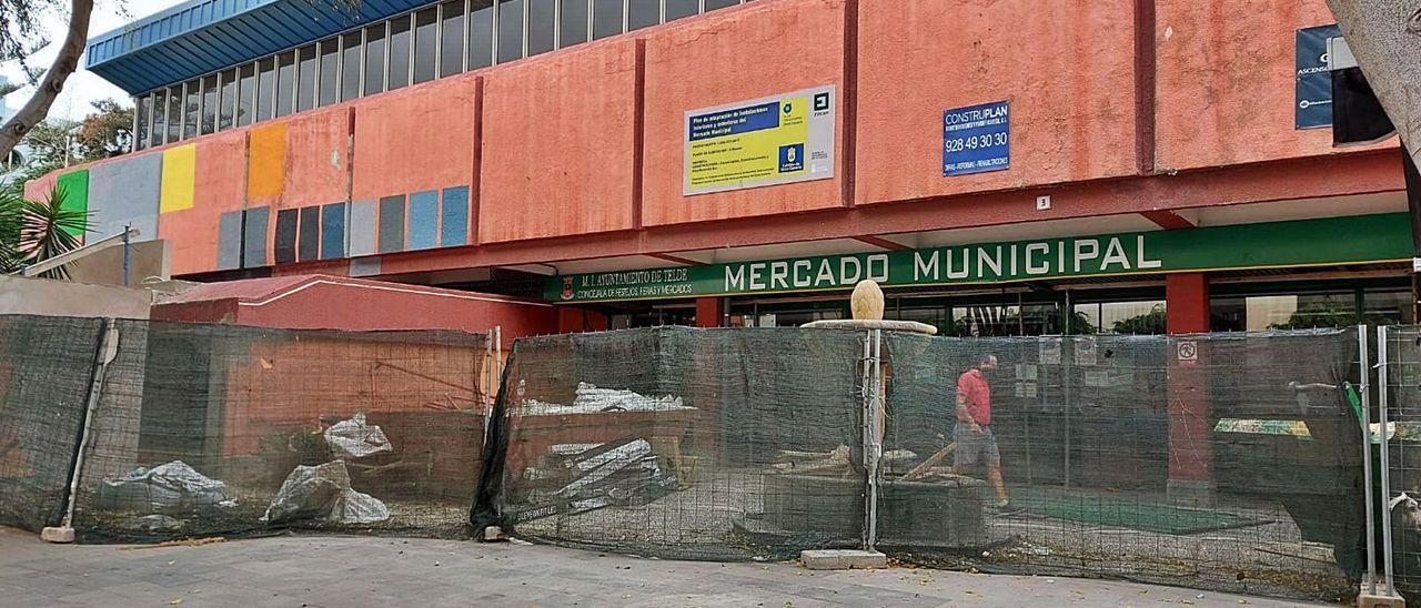 Fachada del mercado municipal con una valla para delimitar las obras que se efectúan en el interior y entorno.