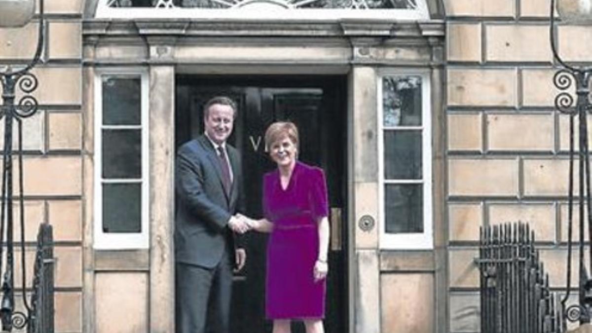 Cameron y Sturgeon en la puerta de la residencia oficial de la jefa del Gobierno escocés, en Edimburgo.