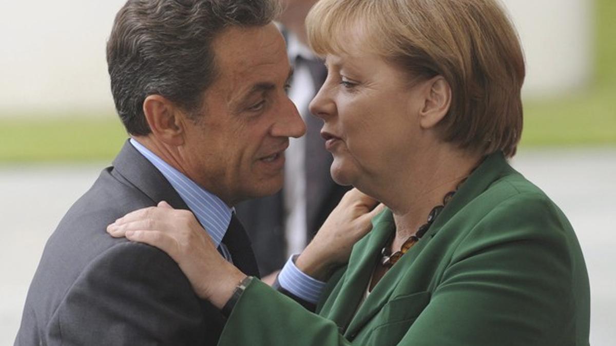 Nicolas Sarkozy y Angela Merkel se saludan a la llegada del dirigente francés a Berlín para abordar con la cancillera alemana el segundo rescate a Grecia.