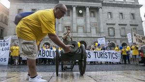 Un vecino enciende, ayer, el cañón de la Barceloneta ante el ayuntamiento en la plaza de Sant Jaume, en la protesta contra los abusos del turismo.