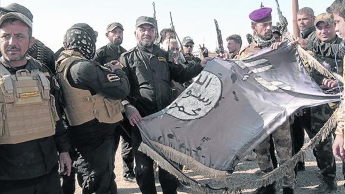 Combatientes del Estado Islámico con la bandera de la organización, en Diyala (Irak).