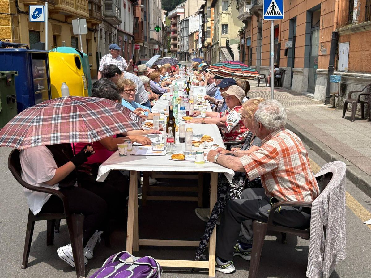 Vecinos de Tineo disfrutan de la comida en la calle.