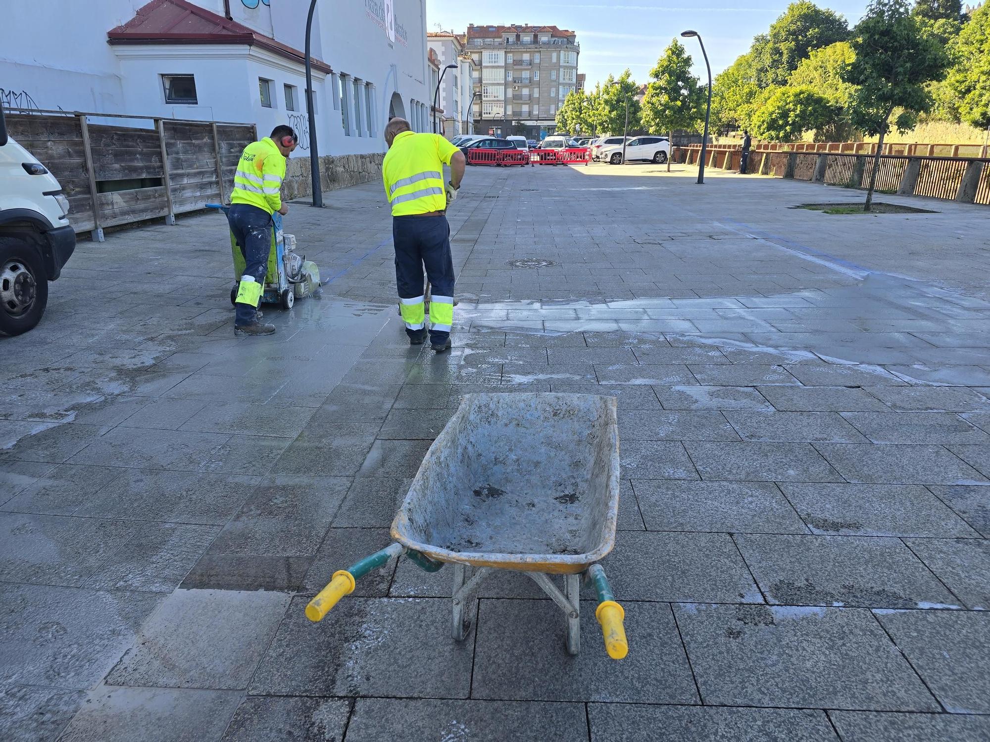 Los operarios eliminan las losas de piedra en el entorno de la plaza de abastos de Vilagarcía para colocar hormigón.