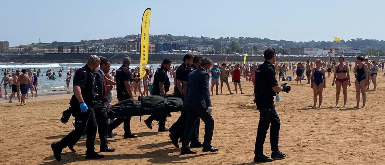 La policía nacional y trabajadores de la funeraria, ayer, llevándose el cuerpo sin vida del hamaquero. | LNE