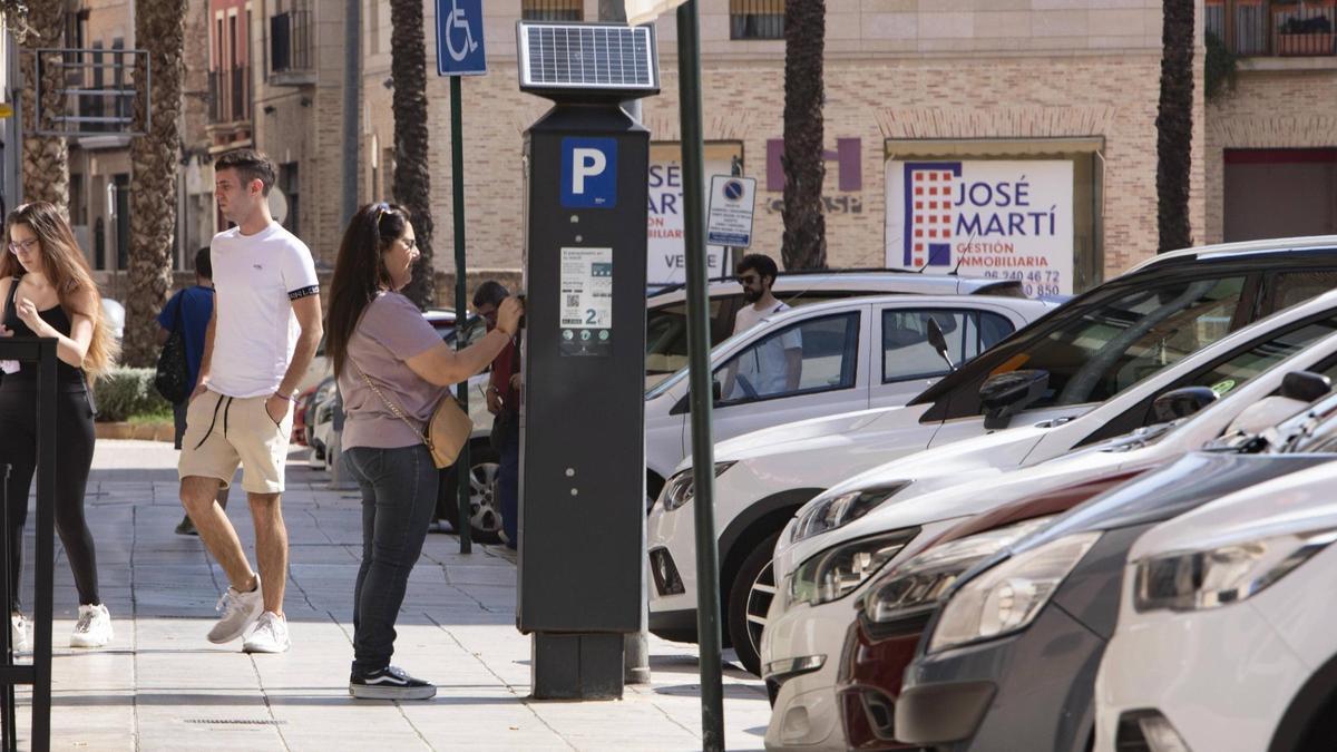 Una mujer abona la zona azul en Alzira, en una imagen de archivo.