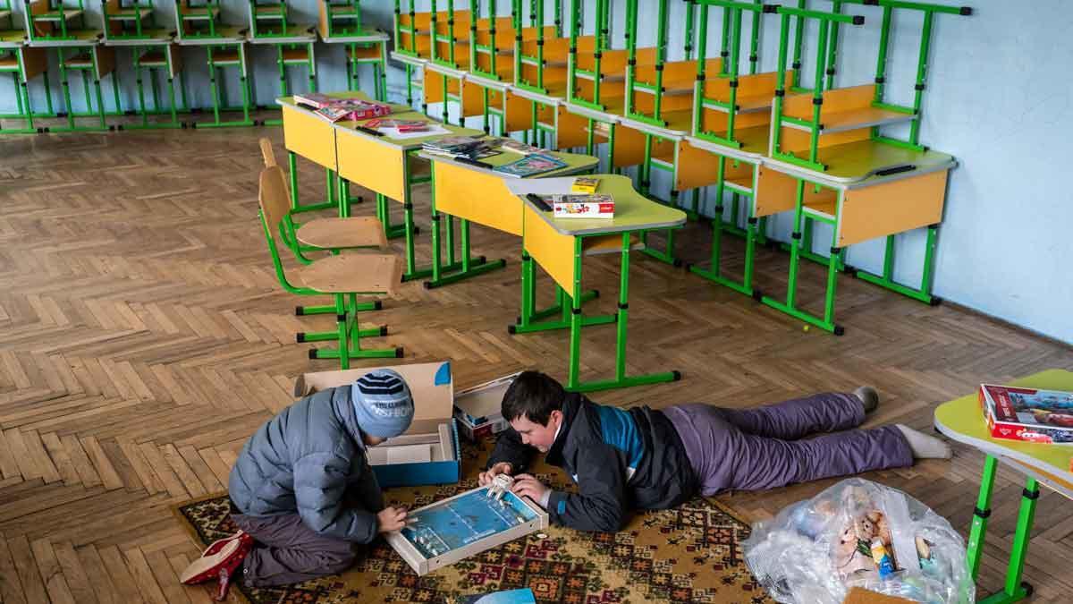 Dos niños juegan en una escuela de Drohobych, en Ucrania, que ahora hace las funciones de refugio