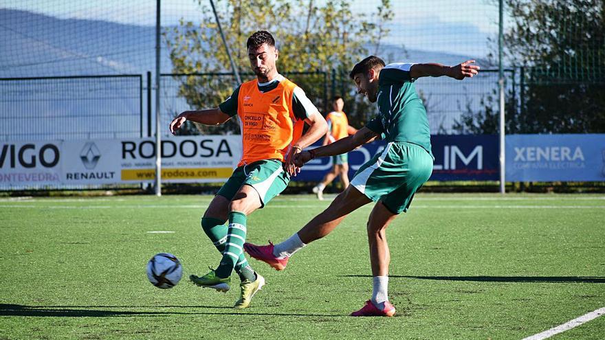 Borja Domingo, del Coruxo, golpea el balón ante la presión de Crespo, ayer en Fragoselo. // R.R.