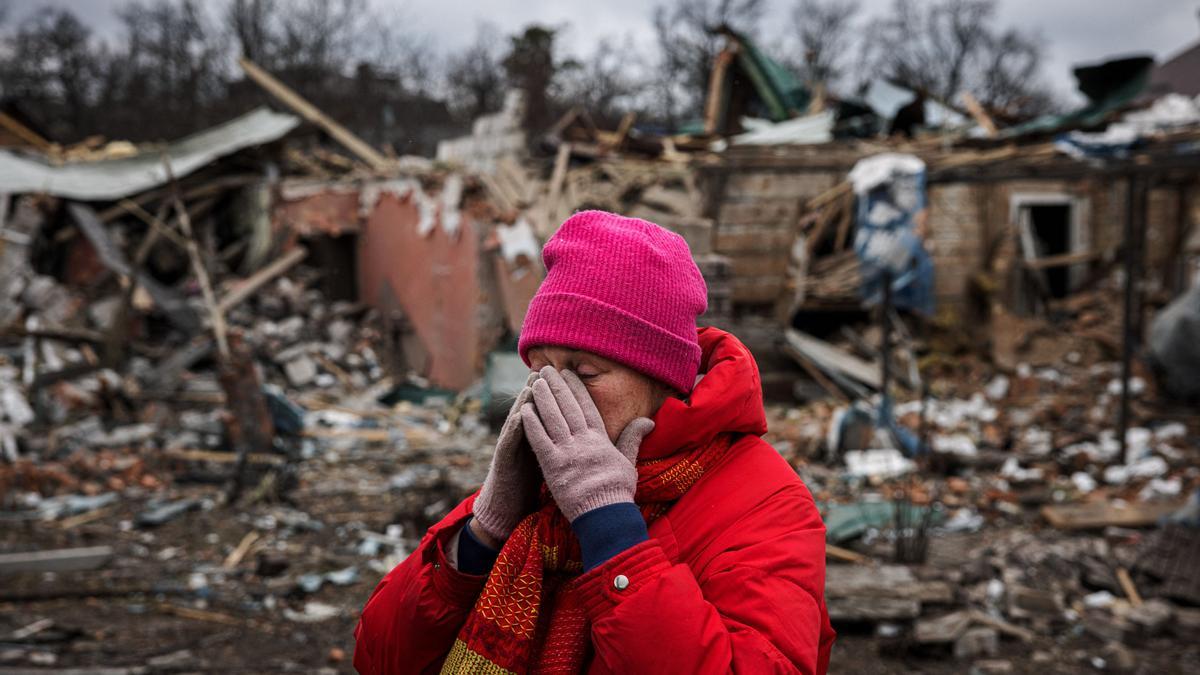 Irina Moprezova, de 54 años, reacciona frente a una casa dañada por un bombardeo aéreo en la ciudad de Irpin, al noroeste de Kiev.