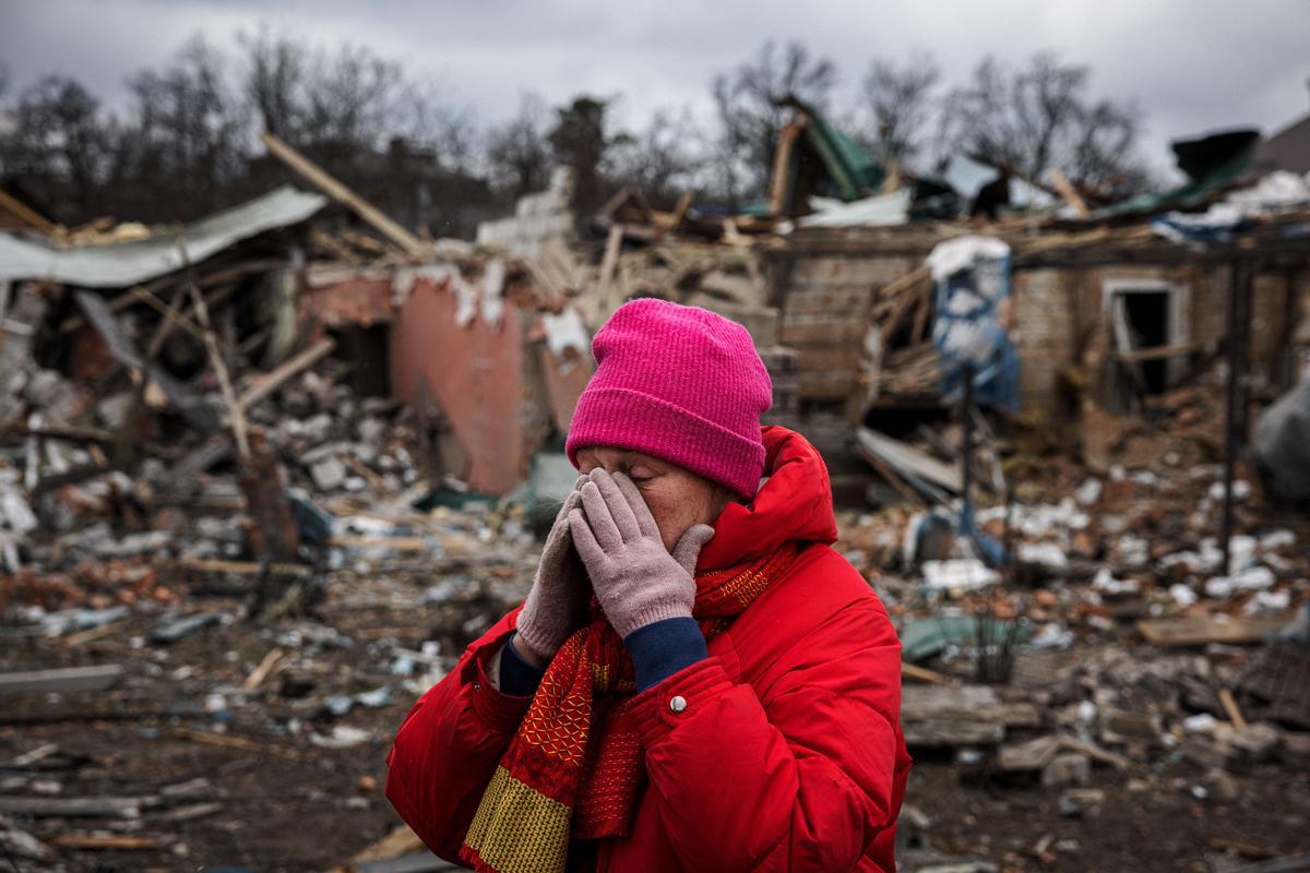 Irina Moprezova, de 54 años, reacciona frente a una casa dañada por un bombardeo aéreo en la ciudad de Irpin, al noroeste de Kiev.