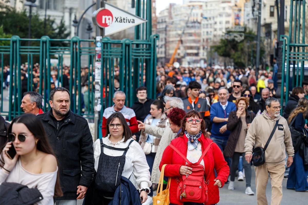 Gente abandonando la plaza del Ayuntamiento tras una la mascletà y dirigiéndose hacia la Estación del Norte.