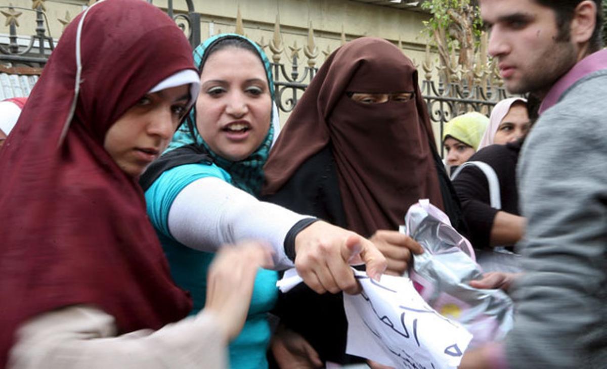 Un voluntari registra les bosses de diverses manifestants egípcies en un punt de control muntat per civils en un dels accessos a la plaça de Tahrir al Caire (Egipte).